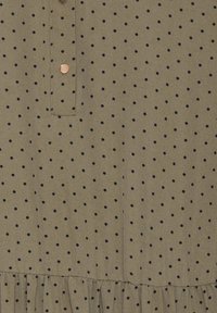 Olivově zelená látka s malými černými tečkami, s knoflíkovou légou a nařaseným volánem na lemu. Měkká textura, ležérní design.