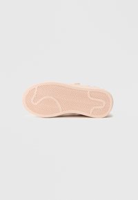 Σόλα παπουτσιού σε ανοιχτό ροζ με ζιγκ ζαγκ μοτίβο πατημασιάς. Λείο υλικό με διακριτικές λεπτομέρειες κοντά στην πλευρά. Ανθεκτικός και ευέλικτος σχεδιασμός.