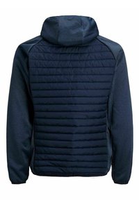 Marinblå jacka med en puffig, vadderad rygg, som har huva och kontrasterande släta ärmar. Materialet verkar mjukt med en subtil textur.