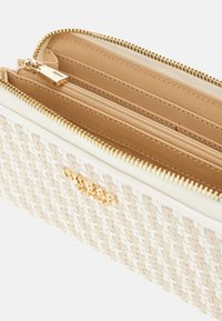 Cremfarbige gewebte Geldbörse mit goldenem Reißverschluss und Beschlägen. Verfügt über mehrere Fächer, darunter ein Reißverschlussfach und ein glattes Lederinterieur.