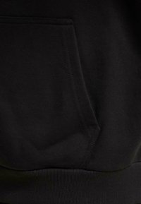 Sudadera con capucha negra que presenta un bolsillo frontal, textura suave y puños y dobladillo elásticos para un ajuste ceñido.