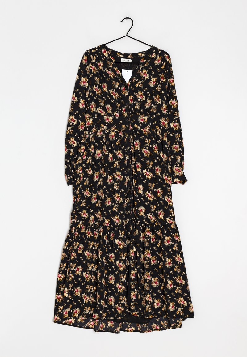 Abito nero a maniche lunghe con bottoni, fantasia floreale rossa e gialla, vita arricciata e gonna a strati, appeso a una gruccia nera su sfondo bianco.