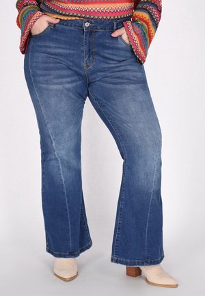 Udsvingende blå denim jeans med sidelommer, knaplukning og let falming. Bæres med lysebeige hæle.