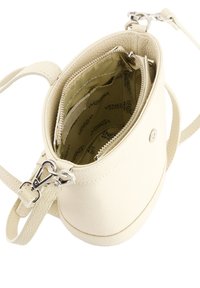 Creme håndtaske med en tekstureret læderoverflade, rund form, lynlåslukning og indvendig stofbeklædning med trykt mærkenavn. Justerbar rem.