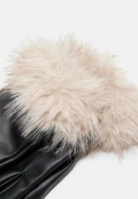 Sorte læderhandsker med en struktureret, fluffy cremefarvet plysmanchet. Handskerne har diskrete syninger langs fingrene og håndleddet.