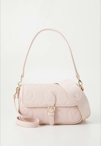 Világos rózsaszín válltáska dombornyomott kör alakú logókkal, arany csattal és levehető, széles szövetpánttal. Minimalista dizájn fehér háttéren.