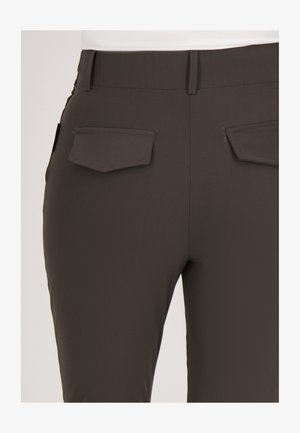 Donkerbruine broek van glad, rekbaar materiaal. Voorzien van twee achterzakken met kleppen en een slim fit ontwerp. Weinig zichtbare stiksels.