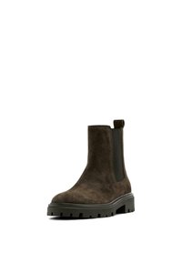 Brązowe zamszowe botki za kostkę z elastycznymi panelami bocznymi i pętelką. Masywna czarna gumowa podeszwa z bieżnikiem zapewniającym przyczepność. Klasyczny design botków Chelsea.