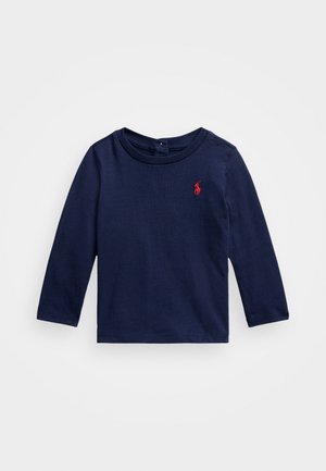 Granatowa koszulka z długim rękawem wykonana z bawełny, z okrągłym dekoltem i małym czerwonym logo po lewej stronie klatki piersiowej. Miękka tekstura.