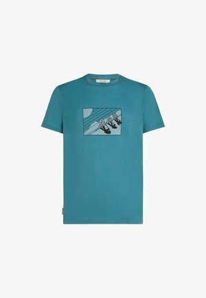 Teal kortærmet t-shirt lavet af blødt stof med et grafisk motiv af tre figurer på en gyngestativ foran en bjergbaggrund.