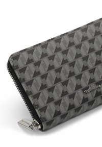 Zipped wallet with a geometric pattern in shades of gray and black. Textured material with a silver zipper pull and logo accent.