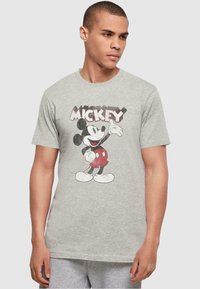 Camiseta de algodón gris con un gráfico vintage de Mickey Mouse en negro y rojo. Mangas cortas y cuello redondo.