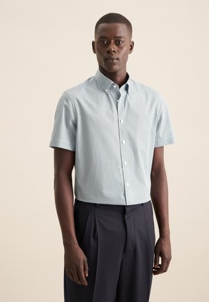 Camicia a maniche corte con bottoni, in un motivo a quadri verdi e bianchi. Tessuto di cotone con una texture morbida, dotata di colletto standard e chiusura frontale con bottoni.