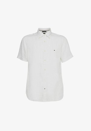 Valkoinen lyhythihainen pellavapaita, jossa on napitettava kaulus, pienen logon vasemmassa rinnassa ja näkyvät napitusratkaisut.