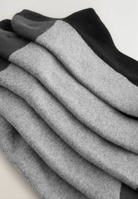 Graue Socken aus einem weichen, strukturierten Stoff, der verschiedene Grautöne von Dunkelgrau bis Schwarz mit glatter Oberfläche und elastischen Bündchen aufweist.