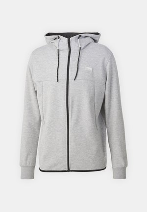 Grå zip-up sweatshirt med hætte, sorte snore og et lille logo-patch. Har kontrasterende sort trim langs fronten og manchetterne.