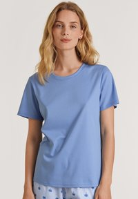 Lichtblauw t-shirt met korte mouwen, gemaakt van soepel materiaal, met een ronde halslijn en een ontspannen pasvorm, gecombineerd met gemusterde pyjamabroeken.