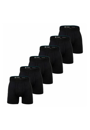 Fünf Paar schwarze Boxershorts mit gebrandeten Taillenbändern, diagonal auf einem weißen Hintergrund angeordnet.