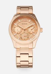 Montre analogique en or rose avec un cadran texturé, trois sous-cadrans et de grands index horaires. Bracelets en maillons métalliques avec une finition polie.