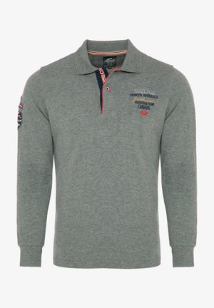 Harmaa pitkähihaisen poolopaita, jossa on kaulus, punaisia ja sinisiä yksityiskohtia, brodeerattua tekstiä ja patch vasemmassa hihassa.