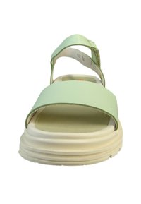 Lyst grøn sandal med en bred rem og justerbar ankelspænde. Blød sål, hvid sål med strukturerede kanter, minimalistisk design.