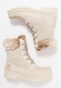 Beige ankelstøvler med overdel i semsket skind og læder, faux fur-krave, metal øjeblikke og en robust gummisål for godt greb.