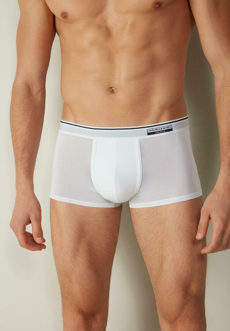 Weiße Boxer-Brief mit enganliegendem Schnitt, aus einem leichten, dehnbaren Material gefertigt. Mit einem schwarz-grauen elastischen Bund mit Markenlogo.