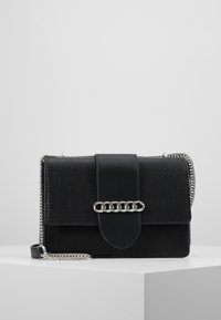 Borsa nera in materiale texturizzato, con dettagli in metallo e chiusura a patta. Presenta una tracolla in metallo a catena removibile. Forma rettangolare.