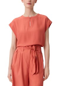 Koralfarbenes Bluse mit strukturiertem Stoff und Schlüsselloch-Ausschnitt, kurzen Ärmeln, kombiniert mit hochtaillierten koralfarbenen Hosen mit gebundenem Bund.