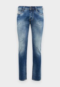 Siniset suoralahkeiset farkut, joissa on kulutettuja yksityiskohtia, haalistumaa ja tavallinen nappisuljenta. Klassinen viiden taskun malli.