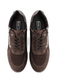 Baskets de sport brunes avec un mélange de matériaux en daim et en textile, dotées de lacets à l'avant, de zips sur les côtés et d'un design texturé.