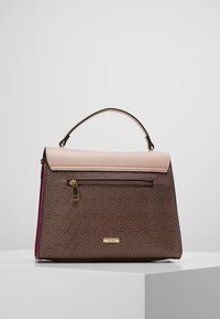 Brązowa i beżowa torebka na ramię z górnym uchwytem, przednią kieszenią na zamek i geometrycznym trójkątnym wzorem na białym piedestale.