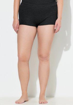 Shorts noirs en matériau doux et extensible avec une large taille, présentant un design simple qui offre un ajustement confortable.