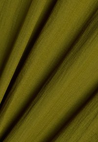 Tissu vert olive avec coutures visibles, présenté plié en plis diagonaux doux avec une surface texturée.