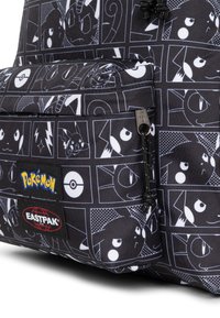 Černý látkový batoh s bílými kreslenými motivy Pokémon, výraznými kapsami a značkovými štítky Pokémon a Eastpak.