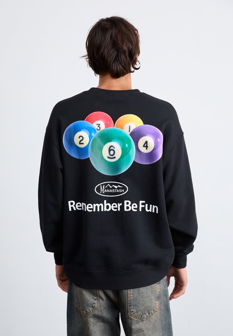 Black sweatshirt featuring a colorful billiard ball graphic and text "Remember Be Fun." Made of soft material, relaxed fit with ribbed cuffs.