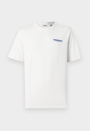 T-shirt branca de manga curta com gola redonda, apresentando o texto pequeno em azul "UNDERDOGS" e um texto adicional menor no canto superior esquerdo do peito.