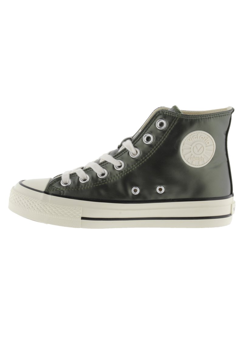 Baskets montantes en matériau vert brillant avec des lacets blancs, œillets ronds, embout en caoutchouc et un logo circulaire sur le côté.