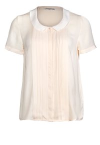 Blouse crème clair avec un col arrondi, des manches courtes et des plis verticaux sur le devant. Tissu lisse et soyeux avec un léger éclat.