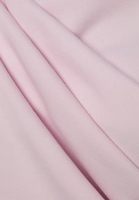 Tessuto rosa chiaro con texture liscia e rigata, che mostra strati piegati e una sottile lucentezza. Ideale per abbigliamento o rivestimenti morbidi.