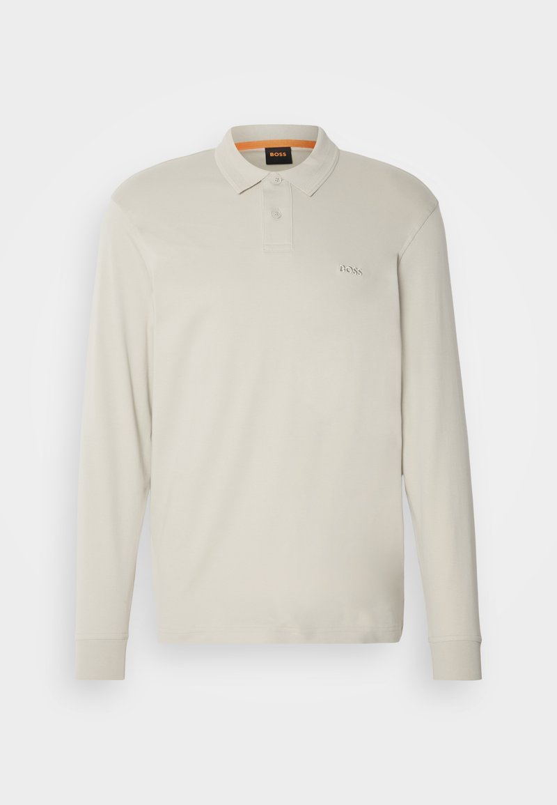 Polo-shirt à manches longues beige clair fabriqué en coton. Dispose d'un col, d'une patte de boutonnage à deux boutons, d'un logo brodé et de poignets côtelés.