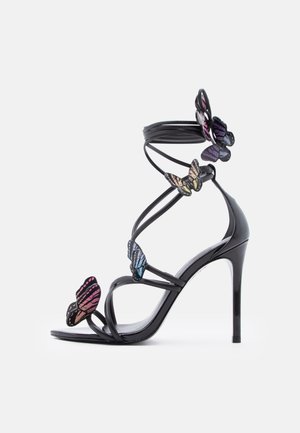 Sort højhælet sandal med tynde remme og dekorative flerfarvede sommerfugledetaljer langs remmene og ankelomviklingen.