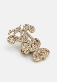 Kuldne juukseklipp, mis sisaldab keerukaid keeriseid ja kõveraid, kaunistatud selgete rhinestone'idega. Kujunduses on kevadel töötav sulg, mis tagab kindla kinnitamise.