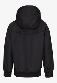 Černá kapucí vybavená bunda z lehké látky. Má elastické manžety a pas. Hladká textura s jednoduchým, minimalistickým designem.