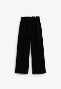 Pantalones negros de pierna ancha con cintura elástica y rayas verticales, hechos de una tela texturizada que refleja la luz sutilmente.
