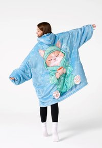 Liels un mīksts pelēkais segas kapuci izgatavots no maiga materiāla, ar multfilmu kaķa dizainu, kuram ir zaļa toga un krūze. Brīvs piegriezums, ar kapuci.