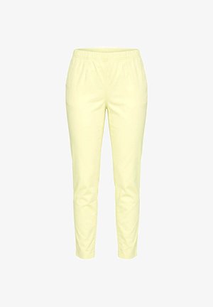 Pantalones ajustados de color amarillo claro con cintura elástica y bolsillos laterales, mostrados de frente sobre un fondo blanco.