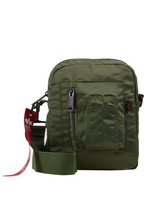Sac en bandoulière vert olive en nylon, avec une poche zippée à l'avant, une sangle ajustable et une étiquette en tissu avec des accents de logo.