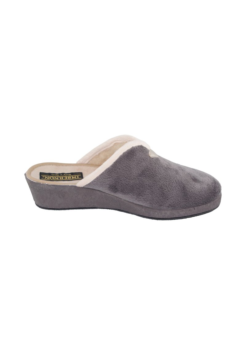 Zapatilla de felpa gris con forro de lana beige, diseño de calzado sin cierre y suela ligeramente en cuña, mostrada de lado sobre fondo blanco.