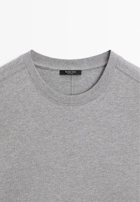 Szara bawełniana koszulka z okrągłym dekoltem, z ryflem na dekolcie i szwami płaskimi; posiada metkę z napisem "Massimo Dutti" i "Wyprodukowano w Indiach."